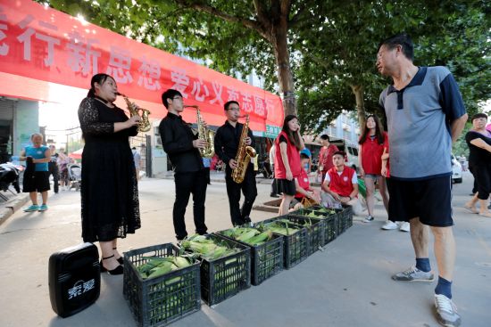 陕西一高校学生街头演奏萨克斯卖玉米助扶贫