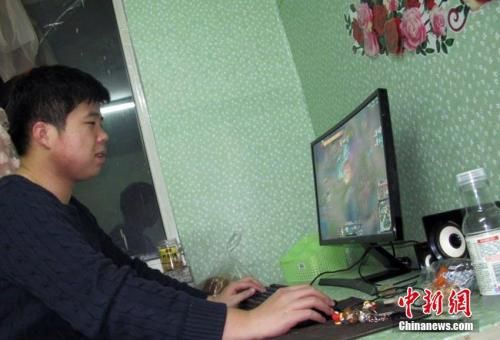 资料图：和许多90后的年轻人一样，男护士王宁喜欢打电脑游戏。一边吃零食，一边打游戏，是王宁下班后最喜欢做的事。 苍雁 摄