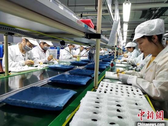 资料图：正在生产耳机的工人。中新网记者 李金磊 摄