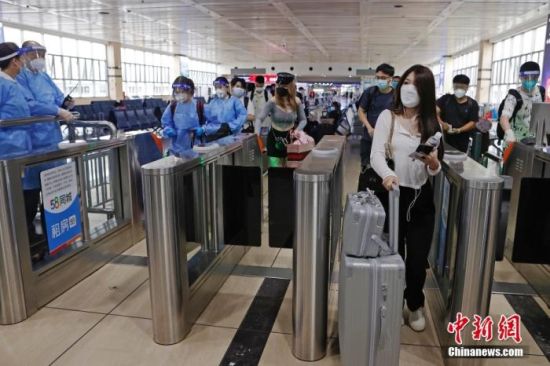 6月10日，旅客在铁路上海站依次有序验票进站。 中新社记者 殷立勤 摄