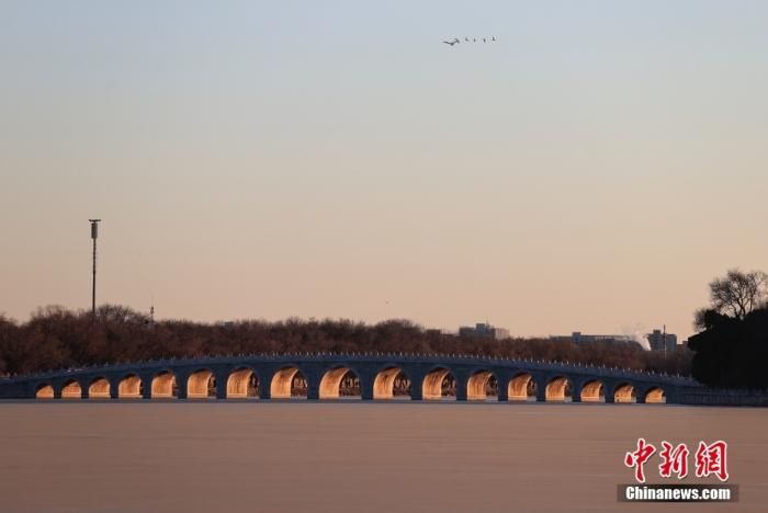 资料图：冬至节气，北京颐和园内，落日余晖照射在十七孔桥所有桥洞的侧壁上，形成“金光穿洞”美景。 中新社记者 韩海丹 摄