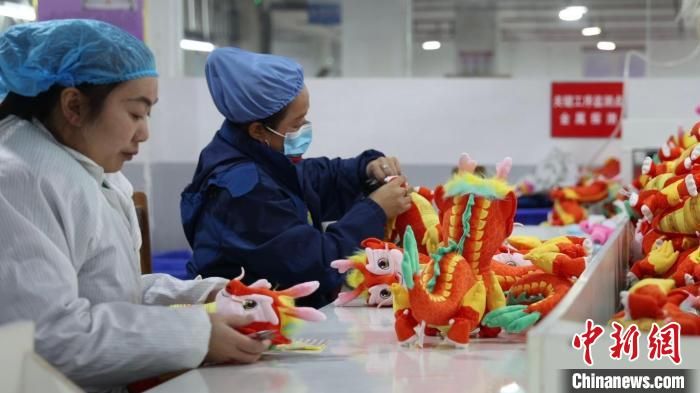 图为陕西安康恒口示范区内，工人制作“龙辰辰”毛绒玩具。　熊涛 摄