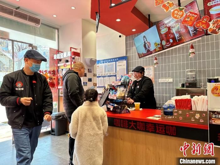 图为陕西凤翔县的连锁饮品店，店员正在指引顾客线上买券。　王宇 摄