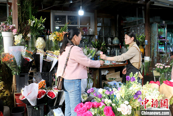 3月23日，安徽省合肥市一家花店里，市民正在挑选鲜花。随着气温回升，鲜花市场迎来一波热度。记者近日在采访中了解到，中国年轻人正在通过各种鲜花消费场景把春天“带回家”，鲜花消费已突破固有的节日专属仪式感，成为年轻人日常“悦己”的重要方式。 中新社记者 张强 摄