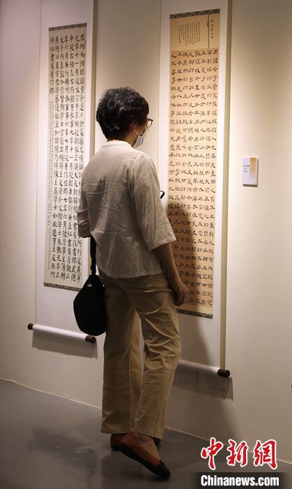 　图为台湾的书法爱好者在现场观摩书法作品。 中新社记者 刘舒凌 摄